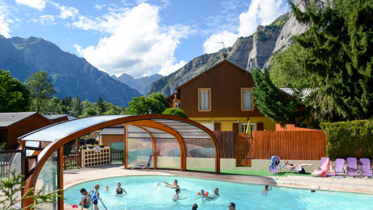 Une piscine extrieure avec terrasse et transats par beau temps