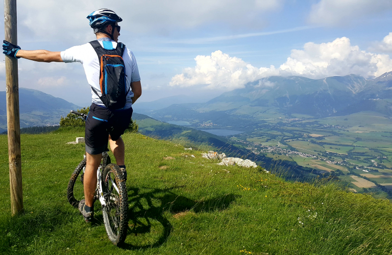 Sportif au sommet d'un sentier VTT et vue sur le plateau matheysin